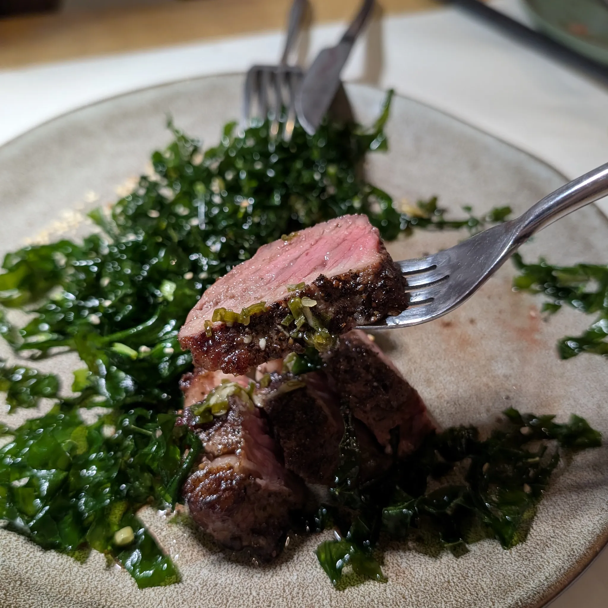 A close-up shot of Grilled Australian Black Angus Sirloin with Deep-Fried Gai Lan and Ginger Scallion Sauce from Psychotic Operator, Selangor, Malaysia