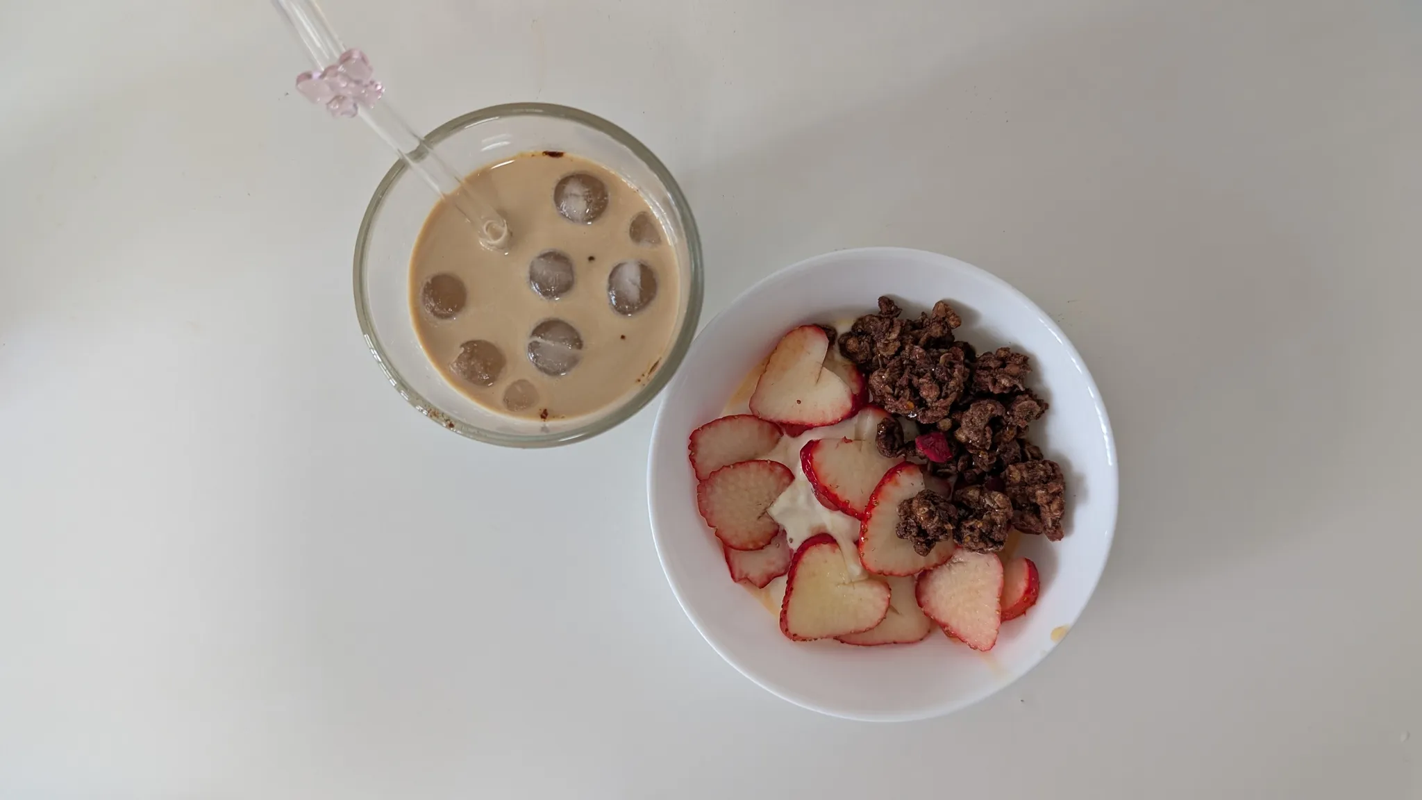 Iced latte made with TAG Espresso coffee capsule and yoghurt bowl with strawberries and chocolate granola as breakfast