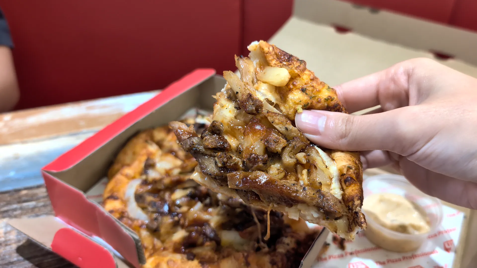 A close-up shot of one slice of Texas BBQ Chicken Original Hand-Tossed Pizza from US Pizza in Singapore